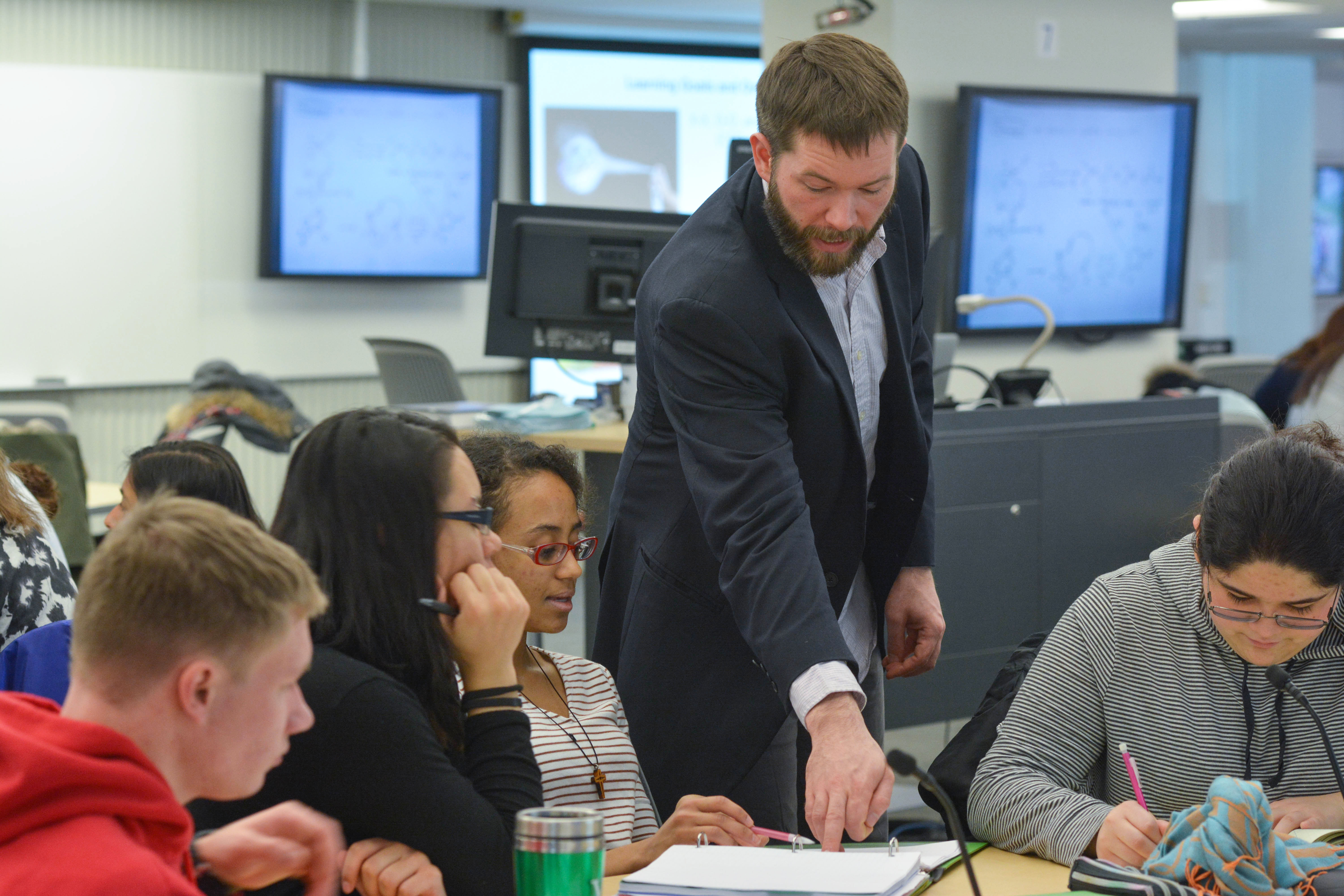 Instructor pointing to a student's work while the student looks on