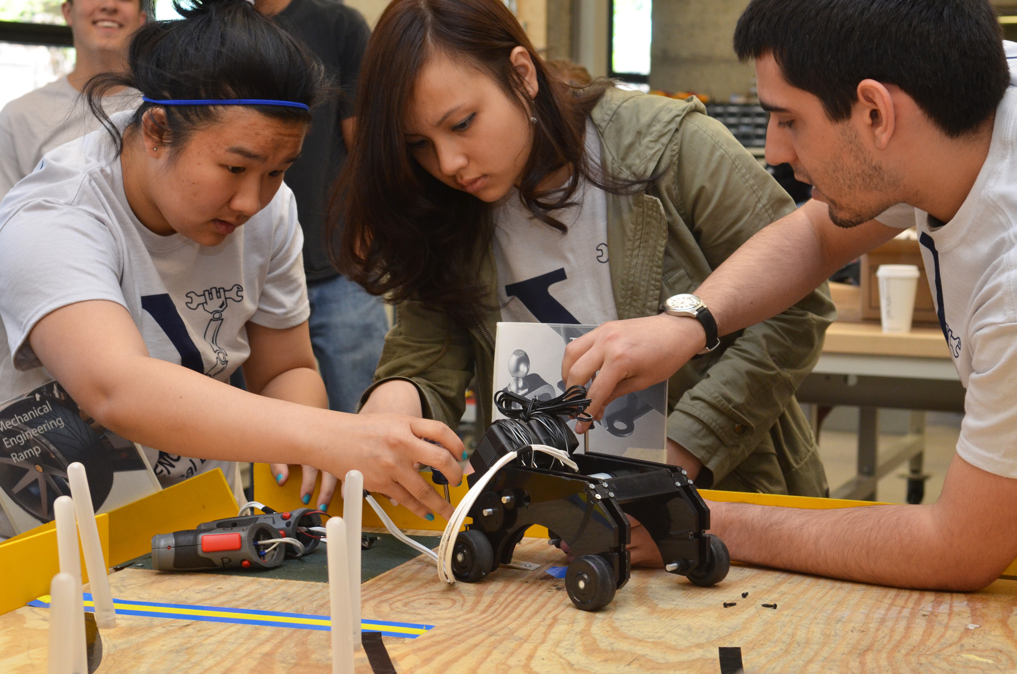 Three students working on a device