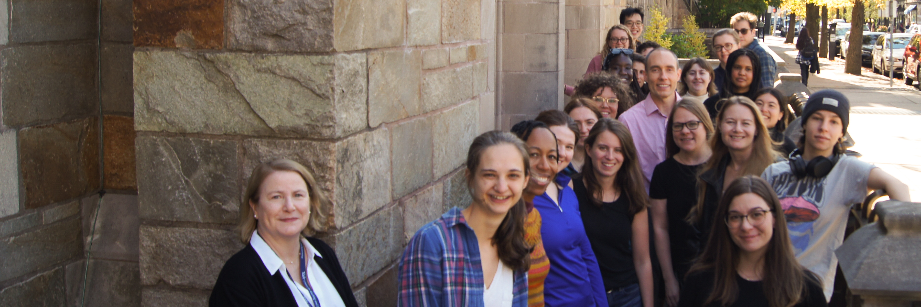 Staff photo of the 2024–25 Graduate Writing Lab Fellows outside the York St. entrance to Sterling Memorial Library