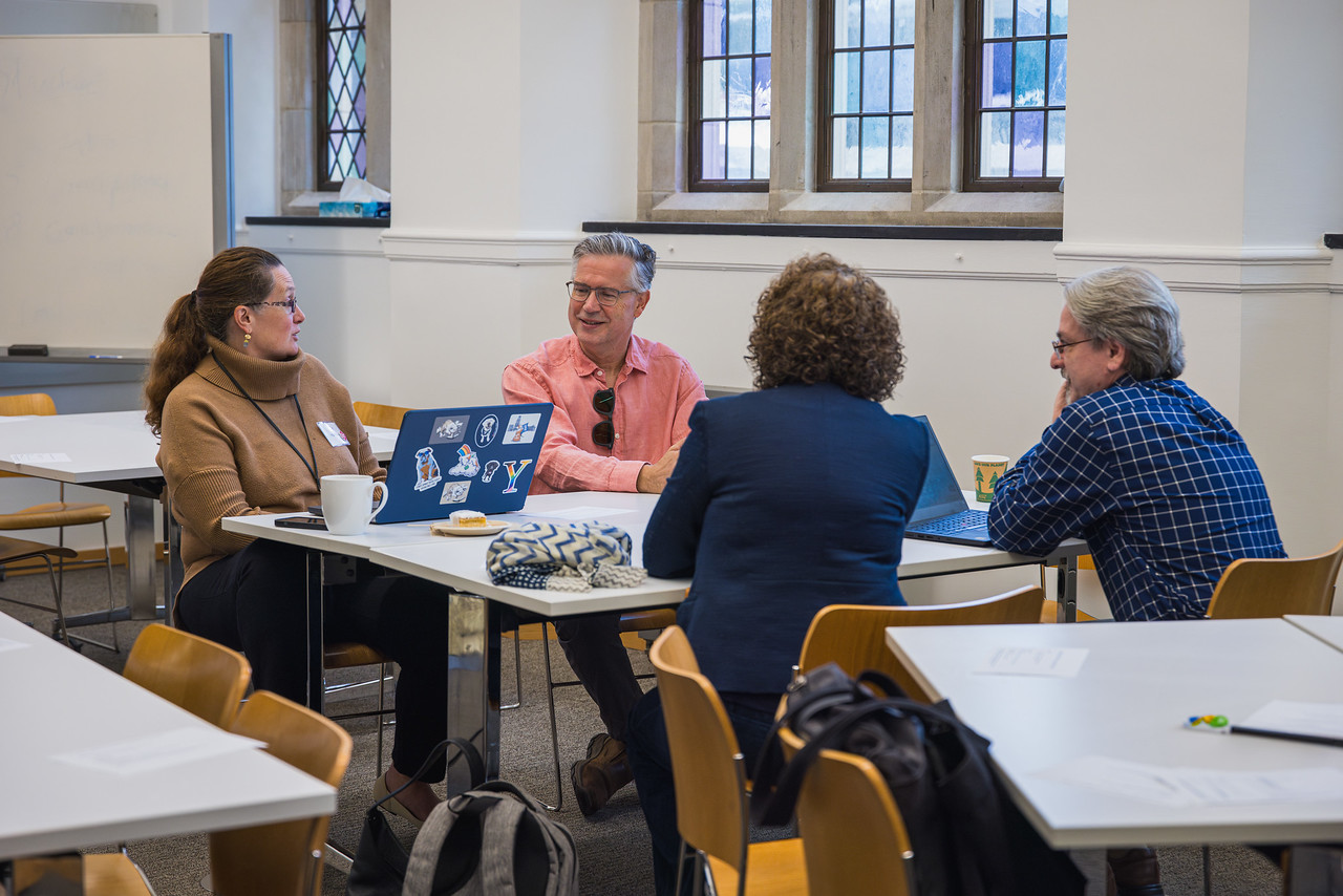 Group of participants having a discussion around a square table