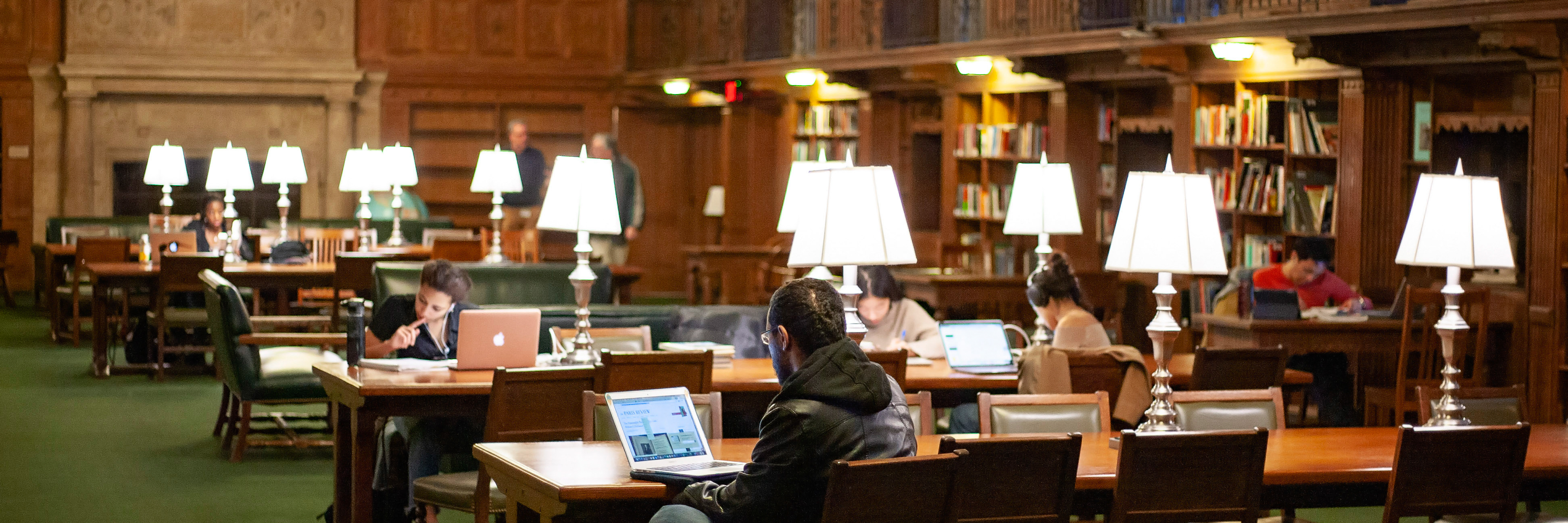 Students writing in a Yale library reading room.
