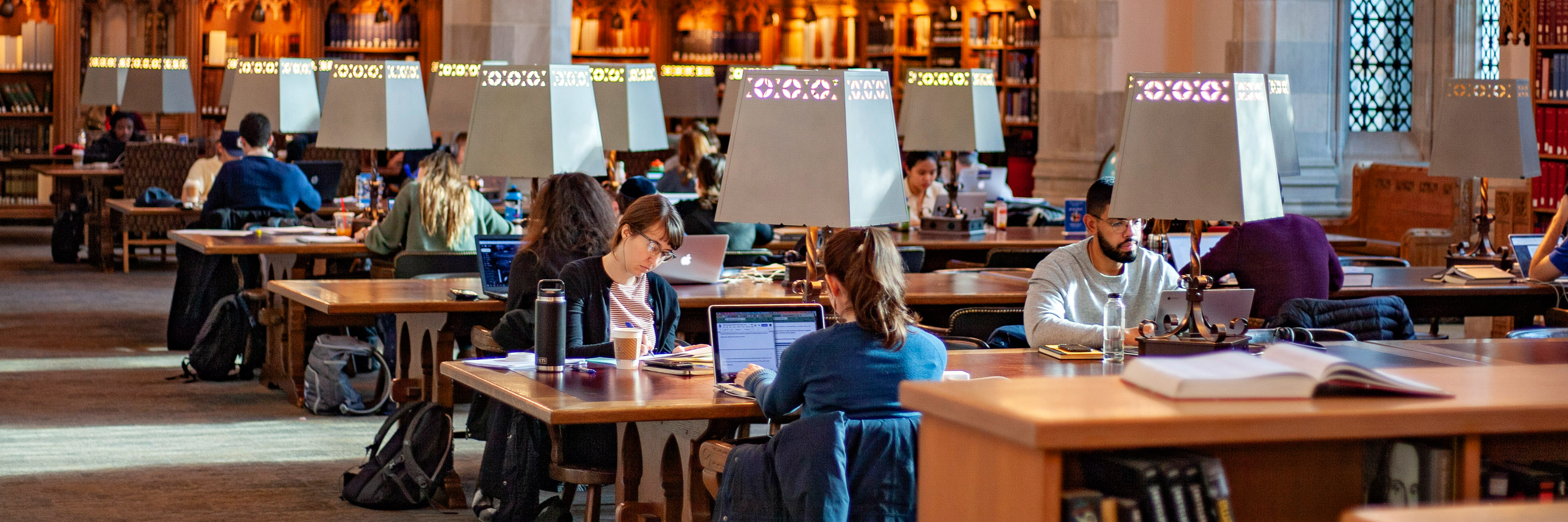 Students writing at tables in the Starr Reading Room.