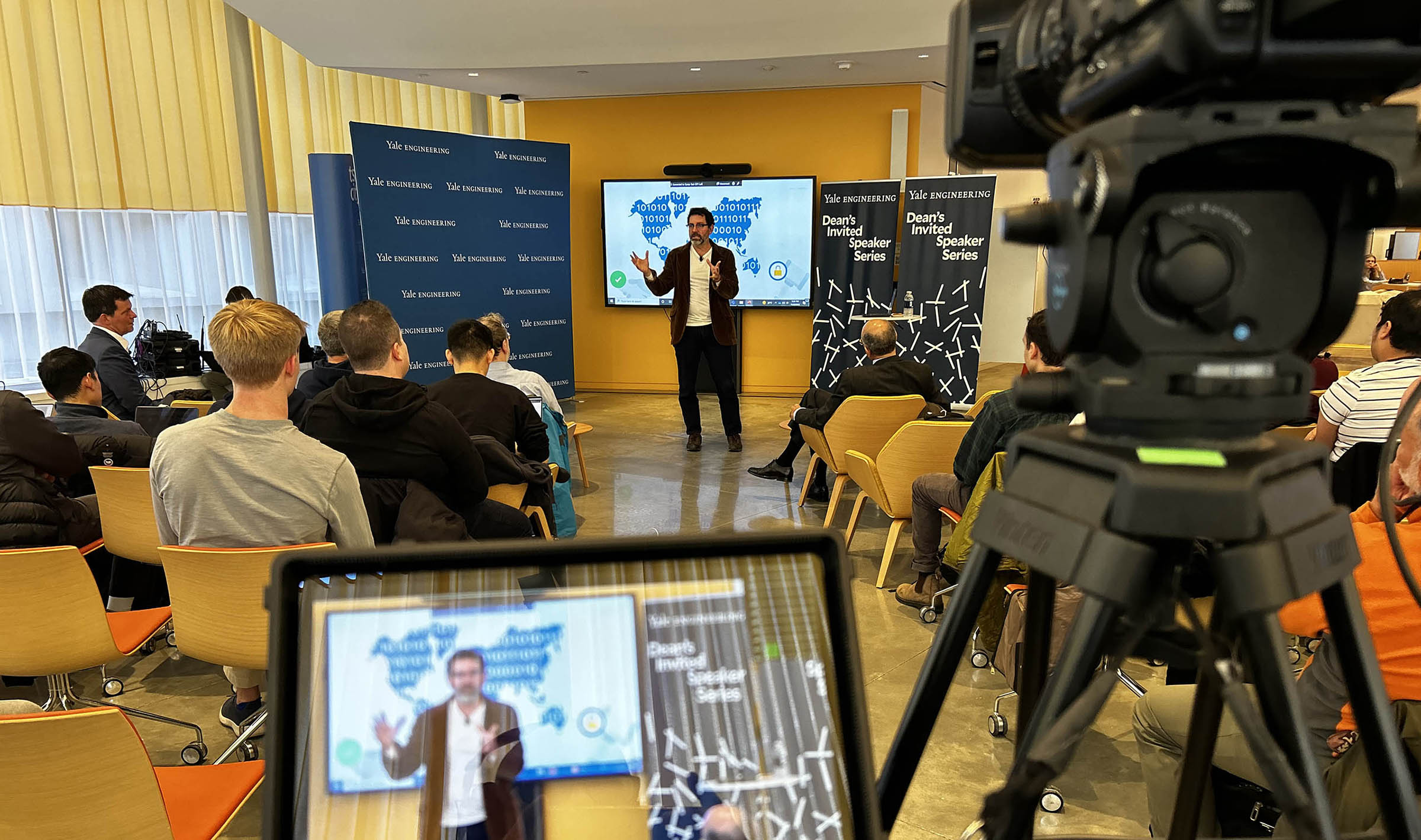 Speaker presenting to audience with slides