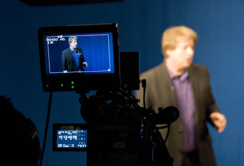 Professor Bloom stands behind a television camera in the Yale Broadcast Studio