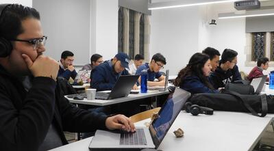 FGLI students sitting at tables/desks doing work in the Poorvu Center.