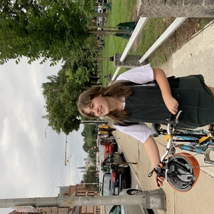 GWL Fellow Lauren Fadiman walking near campus with a bike.