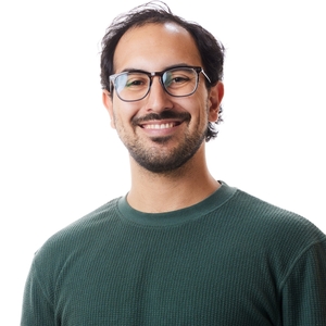 Ryan Pakebusch is a man with glasses wearing a long-sleeve, green shirt.