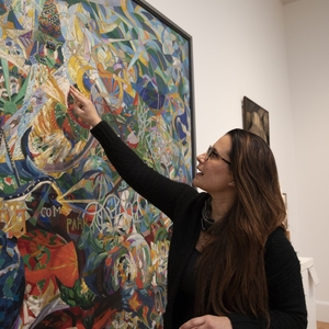 Ximena Benavides, with glasses and dark brown hair, discussing a piece of art at the Yale University Art Gallery.