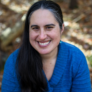 Mira Debs is a woman wearing a blue sweater.