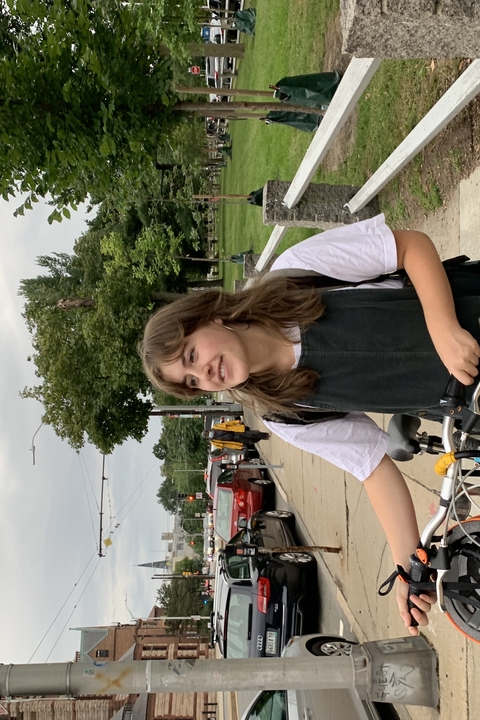 GWL Fellow Lauren Fadiman walking near campus with a bike.