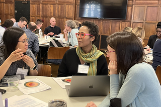 Faculty talking at a table during our annual Course (Re)Design Institute in 2023