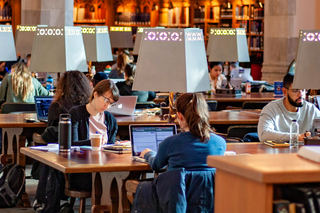 Students writing at tables in the Starr Reading Room.