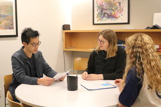 Graduate Writing Lab Fellows discussing papers in small groups around the Poorvu Center.