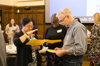 A small group standing together reviewing a document.