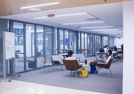 Interior view of the Poorvu Center. Students read on comfortable chairs in an open space.