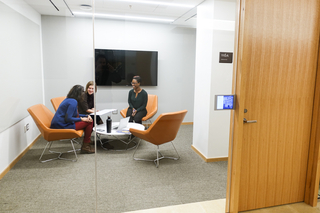 Three graduate students working together in a Poorvu Center meeting room.