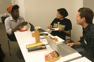 Three graduate students eating together during a break at a Write-in event.
