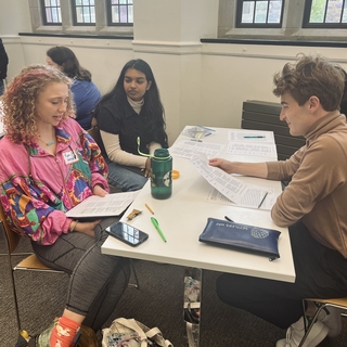 Three Writing Partners participate in a small group discussion at Writing Partners training