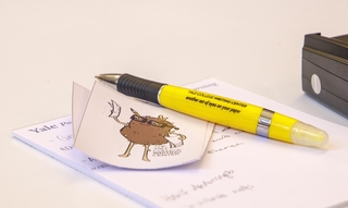 A sticker of the Writing Center's spud mascot and yellow Writing Center pen