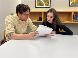 Two people thoughtfully reading some papers.