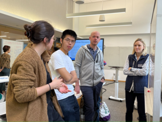 Three people listen closely to one person who is actively talking.