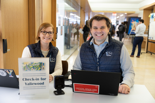 Two Poorvu Center staff members work at an event.