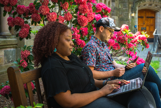 Two students reviewing content on their laptops.