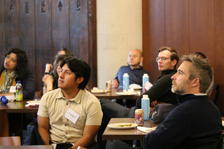 Faculty in a group listen to presentation.
