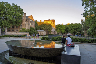 Two students sit looking at Cross Campus.