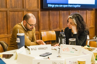 Two people work together at a table.