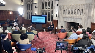Camera crew records instructor speaking to a group of students