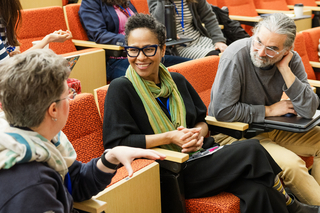 Three people sit together in conversation
