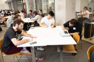Three students work together at a table.